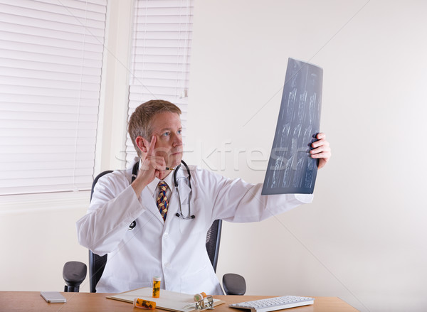Doctor in thought while looking over x-ray chart  Stock photo © tab62