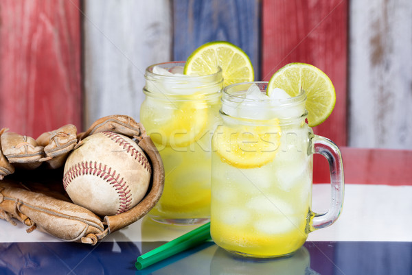 Glass jars filled with cold lemonade and baseball mitt with ball Stock photo © tab62