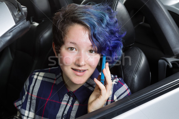Smiling teenage girl seating in car while talking on cell phone  Stock photo © tab62