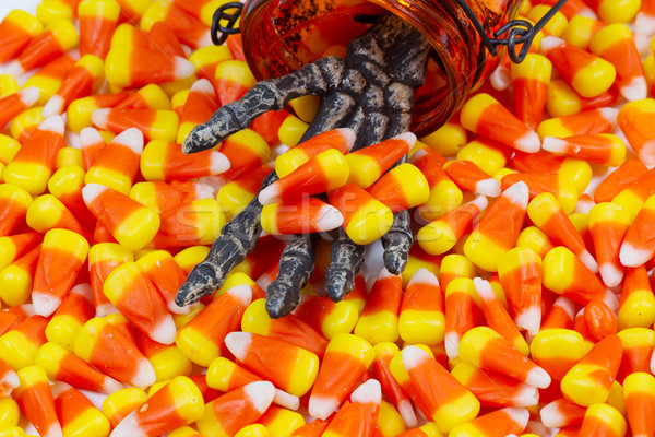 Scary skeleton hand coming out jar giving candy corn  Stock photo © tab62