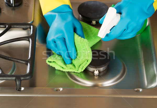 Gloved Hands Cleaning Stove Top Range with Spray bottle and Micr Stock photo © tab62