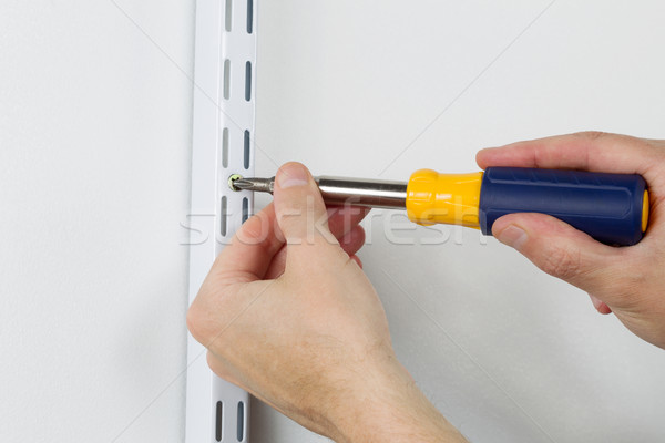 Installing metal bracket on Wall with hand screwdriver  Stock photo © tab62