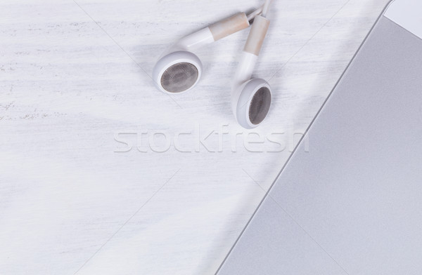 Cell phone and earpieces on clean white desktop background  Stock photo © tab62