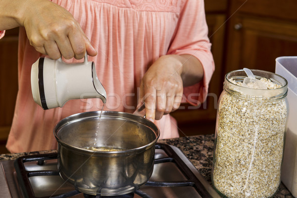 Making Breakfast with adding water to oatmeal on stove top  Stock photo © tab62