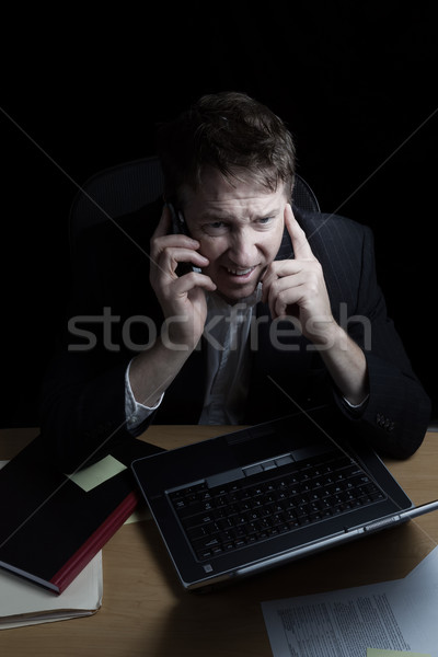 Furie om de afaceri telefon mobil tarziu noapte vertical Imagine de stoc © tab62