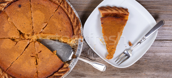 Sliced pumpkin pie with spatula on rustic wooden table  Stock photo © tab62