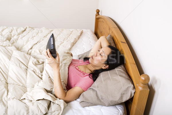 Mature woman looking at alarm clock while trying to sleep  Stock photo © tab62