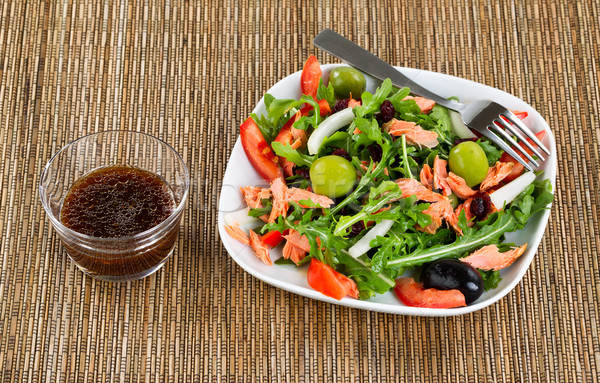 Fresh healthy salad and dressing on natural bamboo place mat Stock photo © tab62
