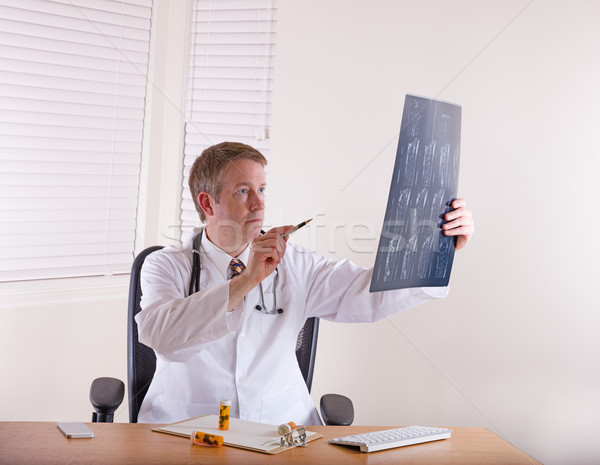 Doctor pointing pen at x-ray chart  Stock photo © tab62