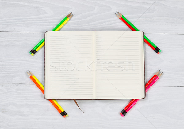 Stock photo: Open notebook with newly sharpen pencils on white desktop 