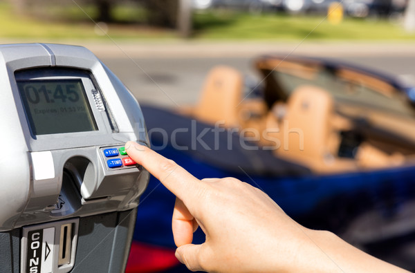 Hand selecting time on parking meter with convertible car in bac Stock photo © tab62