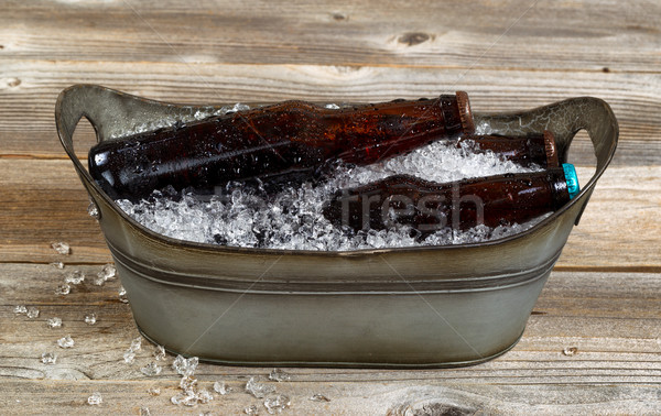 Old metal bucket filled with beer and crushed ice on rustic wood Stock photo © tab62