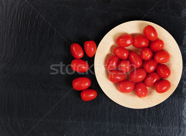 Overhead view of organic cherry tomatoes in bamboo plate on slat Stock photo © tab62