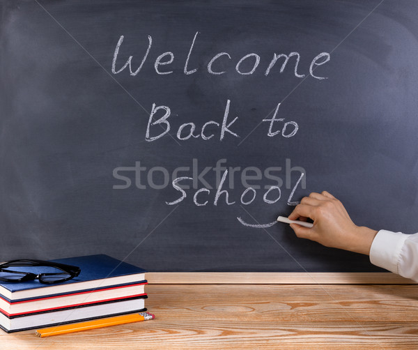 Teacher placing smile symbol on welcome back to school message w Stock photo © tab62