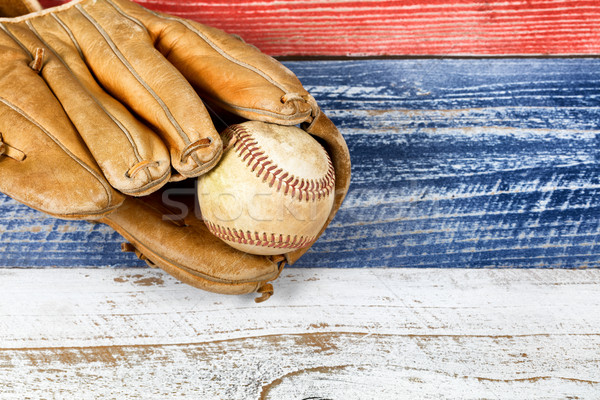 Old worn baseball mitt and ball on faded boards painted in Ameri Stock photo © tab62