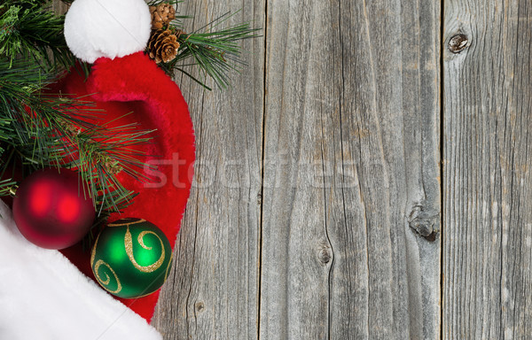Santa cap with ornaments and evergreen branch on wooden boards Stock photo © tab62