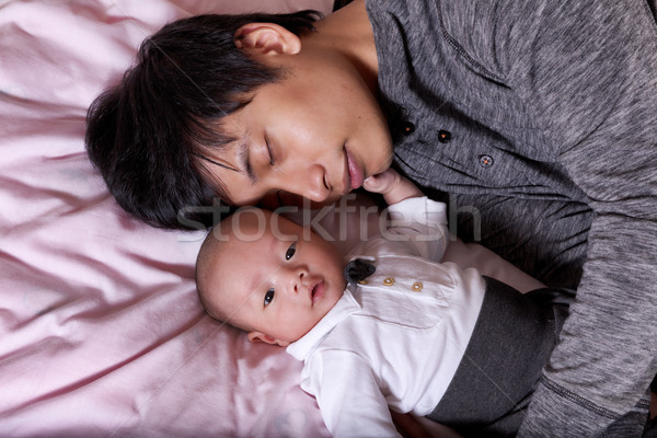 Restless infant baby boy with his sleeping father Stock photo © tab62