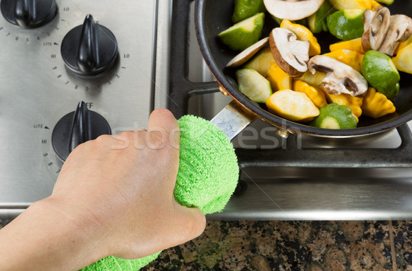 Holding frying pan with green cloth Stock photo © tab62