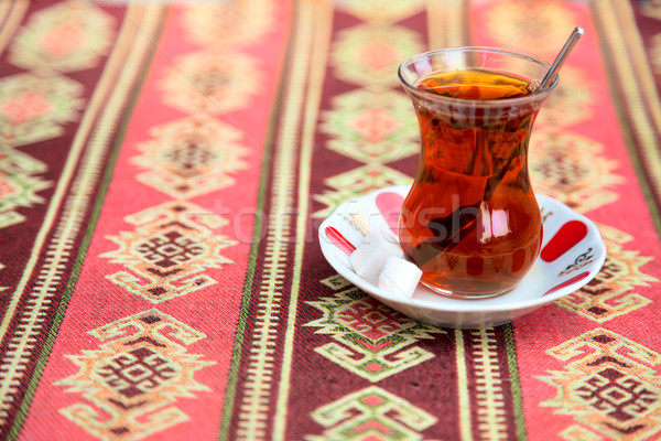 Turkish tea in traditional glass cup on handmade arabic tableclo Stock photo © Taiga