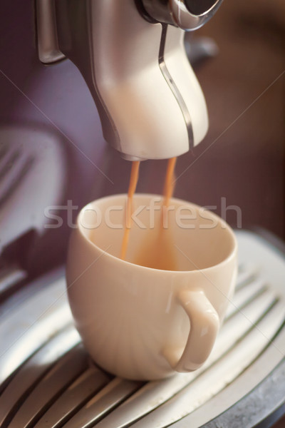 White cup standing on the grating of coffee machine with coffee  Stock photo © TanaCh