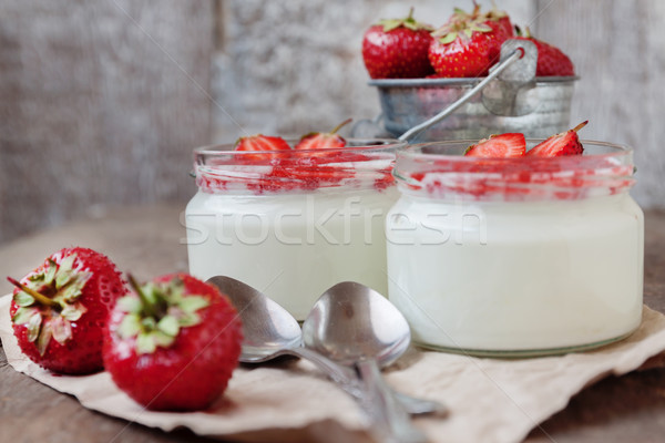 Yogurt with jam sauce in glass and a bucket of fresh strawberrie Stock photo © TanaCh