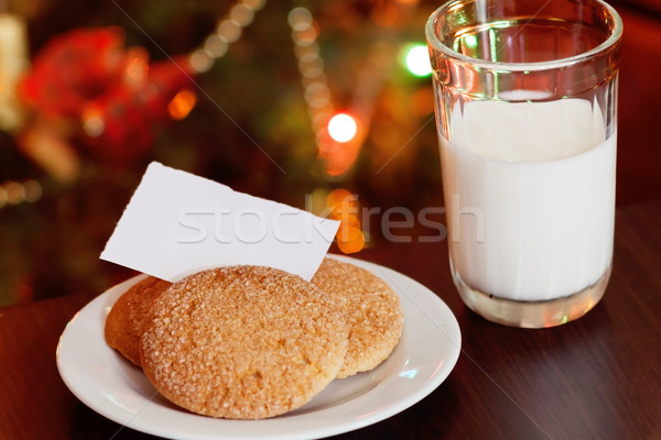 Christmas cookies and milk with note for Santa in front of light Stock photo © TanaCh