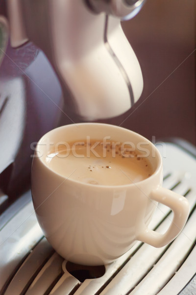 White cup standing on the grating of coffee machine with coffee  Stock photo © TanaCh
