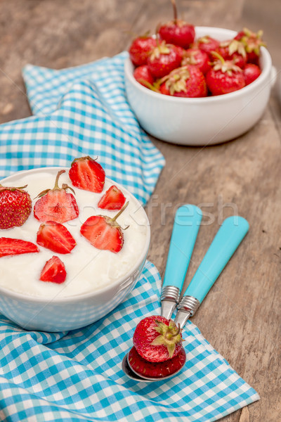 Kubek jogurt świeże truskawek niebieski łyżka Zdjęcia stock © TanaCh