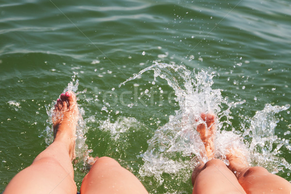 Two pairs of feet splash in the water Stock photo © TanaCh