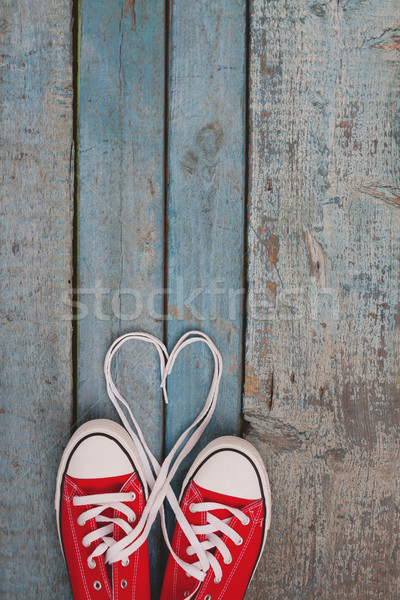 A pair of red retro sneakers on a blue wooden background, laces  Stock photo © TanaCh