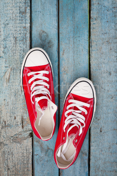 Red retro sneakers on a blue wooden background Stock photo © TanaCh