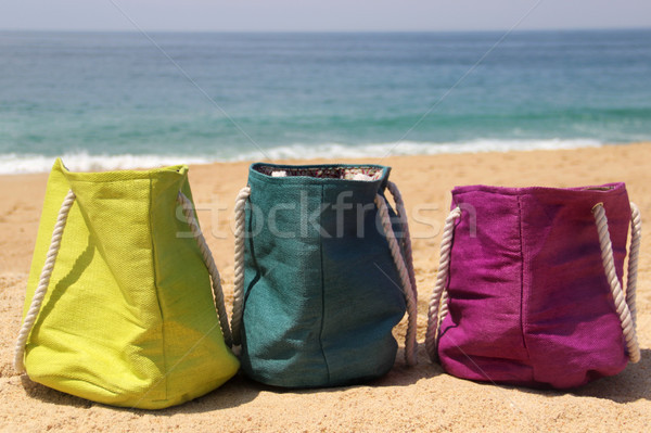 Vivid multicolored beach bags on the seashore  Stock photo © tannjuska
