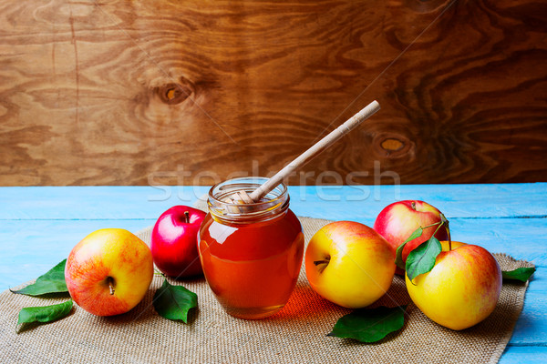 Honey glass jar and apples on rustic background copy space Stock photo © TasiPas