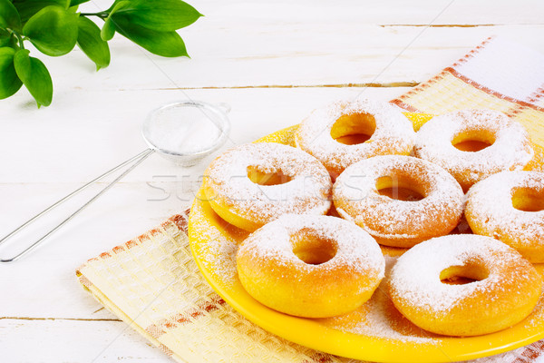 Stock photo: Donuts with caster sugar served on yellow plate