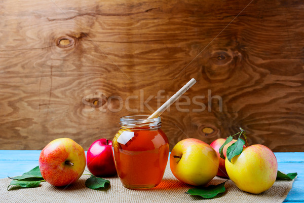 Glass honey jar with dipper and fresh apples, copy space Stock photo © TasiPas