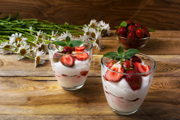 Layered strawberry yogurt dessert on wooden background Stock photo © TasiPas