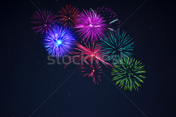 Pink purpe blue green fireworks over starry sky Stock photo © TasiPas