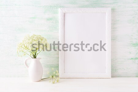 White frame mockup with delicate wild field flowers in pitcher Stock photo © TasiPas