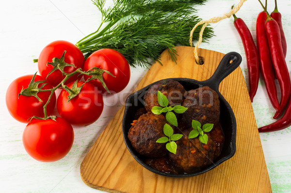 Grilled meatballs with chili pepper and tomato served in cast ir Stock photo © TasiPas