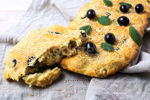 A piece of Italian bread Focaccia with olive and herbs Stock photo © TasiPas