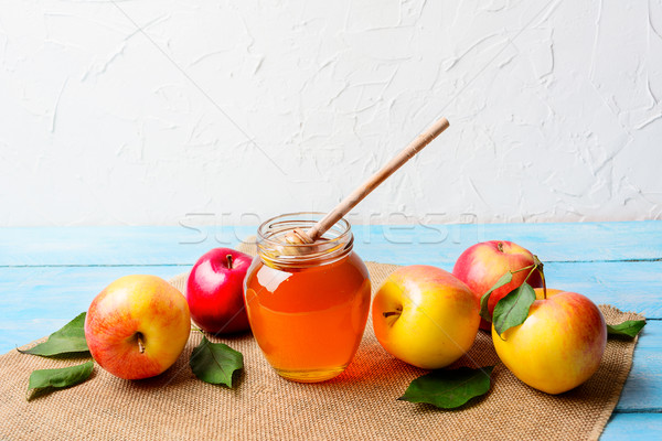 Glass honey jar with dipper and apples copy space Stock photo © TasiPas