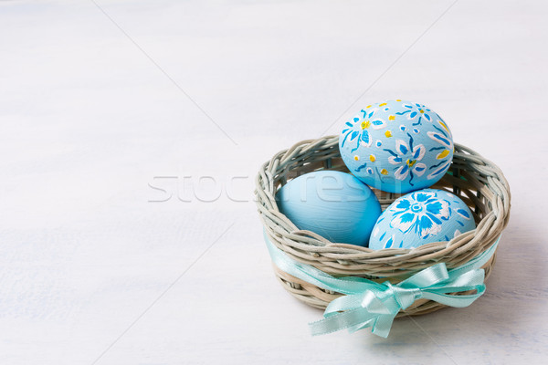 Easter pale blue painted eggs in the wicker basket Stock photo © TasiPas