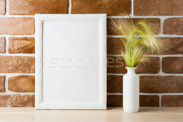 White frame mockup with ornamental grass near exposed brick wall Stock photo © TasiPas