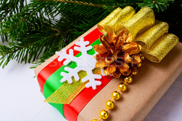 Christmas gift box with golden ribbon, pine cone and beads Stock photo © TasiPas