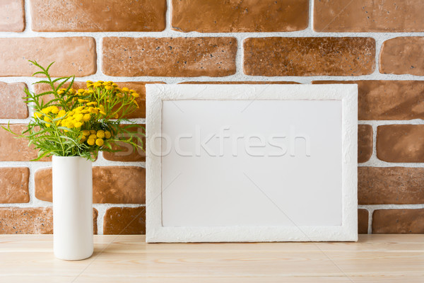 White landscape frame mockup with yellow flowers near exposed br Stock photo © TasiPas
