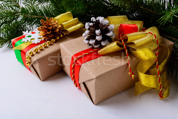 Christmas presents decorated with snowy and golden pine cones Stock photo © TasiPas