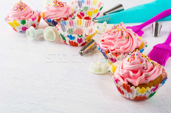 Pink birthday cupcakes  and cookware background Stock photo © TasiPas
