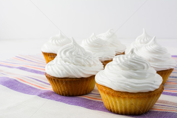 White cupcakes on the striped  linen napkin close up Stock photo © TasiPas