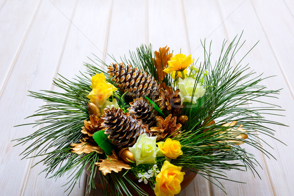 Christmas table centerpiece with golden pine cones and fir branc Stock photo © TasiPas