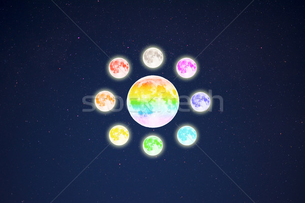 Circle of rainbow colored full moons on starry sky background Stock photo © TasiPas